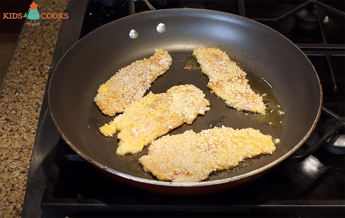 cooking breaded chicken in pan with oil